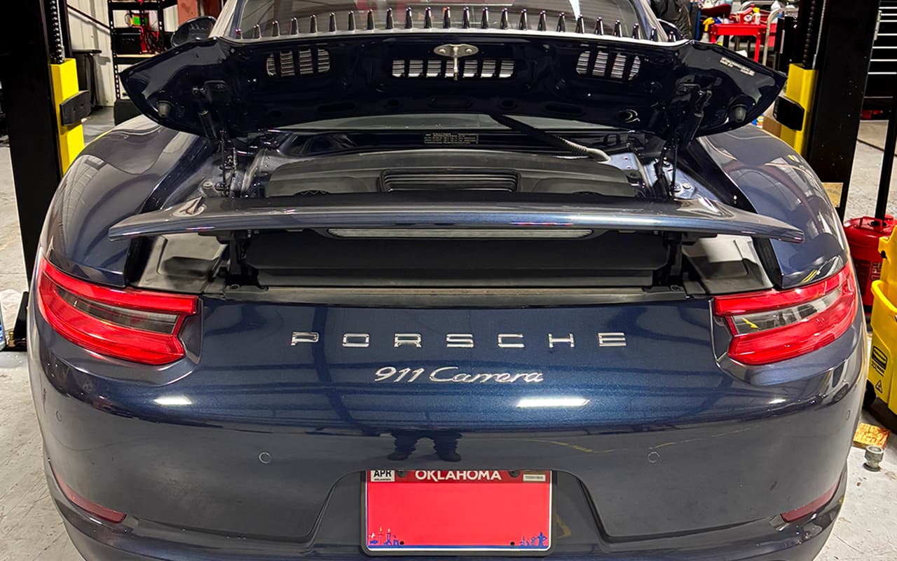 Porsche 911 with open engine bay inside the shop